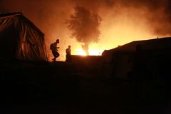 Flyktninger som flykter fra brannen i Morialeiren. Bilde:  Manolis LAGOUTARIS / AFP / NTB