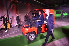 Kronprinsen kjørte elbilen Paxster ut fra scenen. Regionsjef Odd Rune Rennemo t.h. Foto: Birger Morken/ Posten Norge