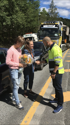 Ingrid og Arthur Thorklidsen var de første som kjørte på ny E18 mellom Tvedestrand og Arendal. Her mottar de blomster fra Nye Veiers Stian Blindheim.