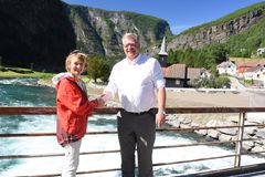Skred- og vassdragsdirektør i NVE, Anne Britt Leifseth og ordførar i Aurland kommune Noralv Distad, ved Flåmselvi med Flåm kirke i bakgrunnen. Foto: Erik Due