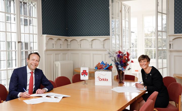 (f.v.) Jaan Ivar Semlitsch, konsernsjef i Orkla, og Grete Herlofson, generalsekretær i Norske Kvinners Sanitetsforening, signerer avtalen om å hjelpe sårbare grupper som er særlig berørt av koronapandemien. Foto: Trygve Indrelid, NTB
