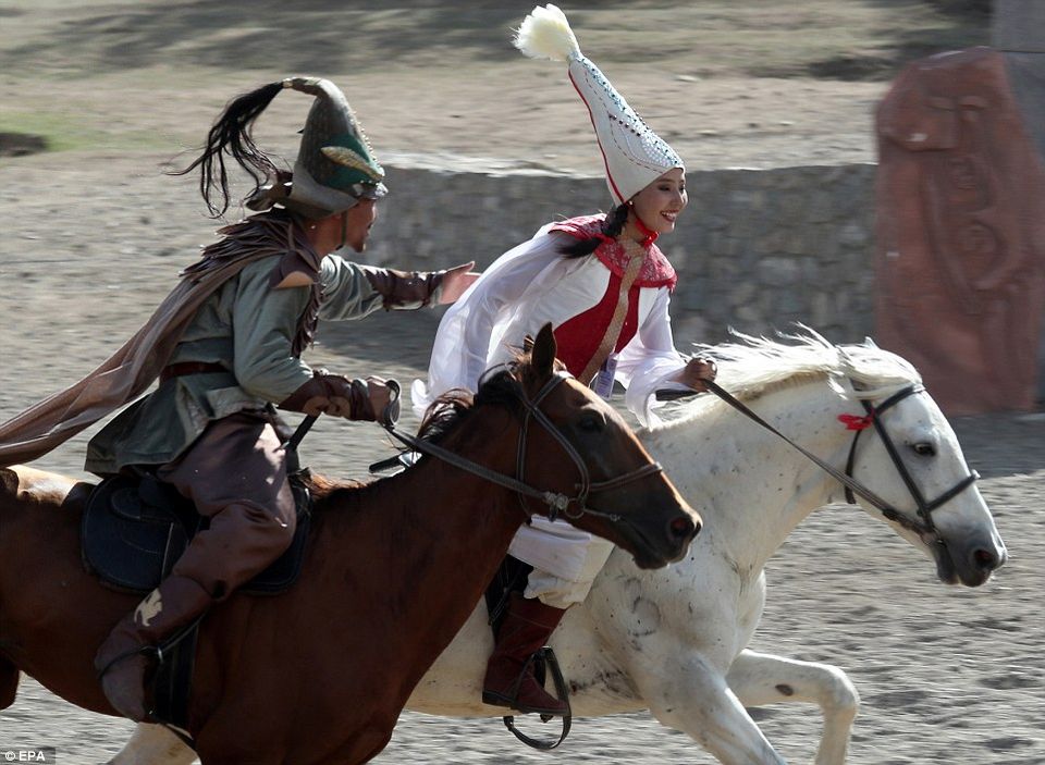 A traditional Turkic game featuring a female rider galloping past a male competitor and humorously flicking her whip at him as he exerted himself to catch up.