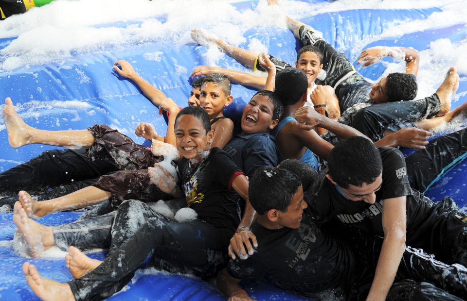 Barn som leker på en vannsklie i Gaza