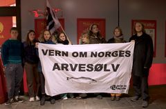 Aktivister fra Kristiansand Natur og ungdom klistret mandag kveld opp advarsler mot oppdrettslaks hos butikker i Kristiansand sentrum.