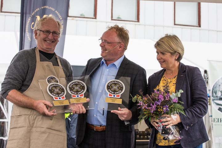 En fornøyd Jørn Hafslund mottar Spesialitet-merkene sine under Bergen Matfestival. Fra venstre: Jørn Hafslund, fiskeriminister Per Sandberg og direktør i Matmerk, Nina Sundqvist. Foto: Janneche Strønen/Bergen Matfestival