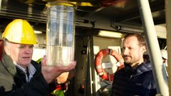Stein Kaartvedt og kronprins Haakon kikker på nærmere på en vannprøve med plankton og bunndyr fra Oslofjorden. Foto: Elina Melteig/UiO