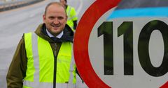 Samferdselsminister Jon Georg Dale ved  skilt for 110 km/t.