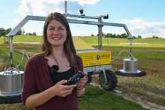 Stipendiat Elisabeth Gautefall Hiis under feltarbeid på Kjerringjordet i Ås, hvor forskerne bruker en robot utviklet av NMBU og Adigo til å måle lystgassutslipp fra jord. Foto: Tonje Lindrup Robertsen