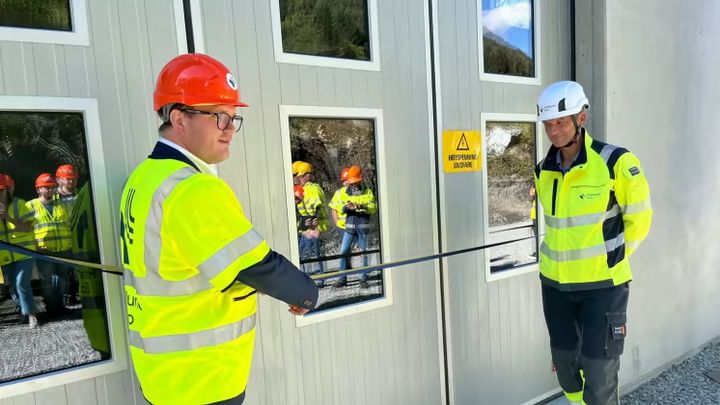 Statssekretær Aleksander Øren Heen i Klima- og miljødepartementet klipper snoren som markerer den offisielle åpningen. Daglig deler i Mork kraftverk, Halvor Kr. Halvorsen bistår.