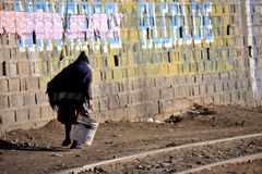 En bostedsløs kvinne går med en bøtte i hånden i Potosí, Bolivia. Omtrent 39 prosent av bolivianere lever i fattigdom, som er et av de høyeste nivåene i Sør-Amerika. Foto: ILO/e12926/M. Crozet.