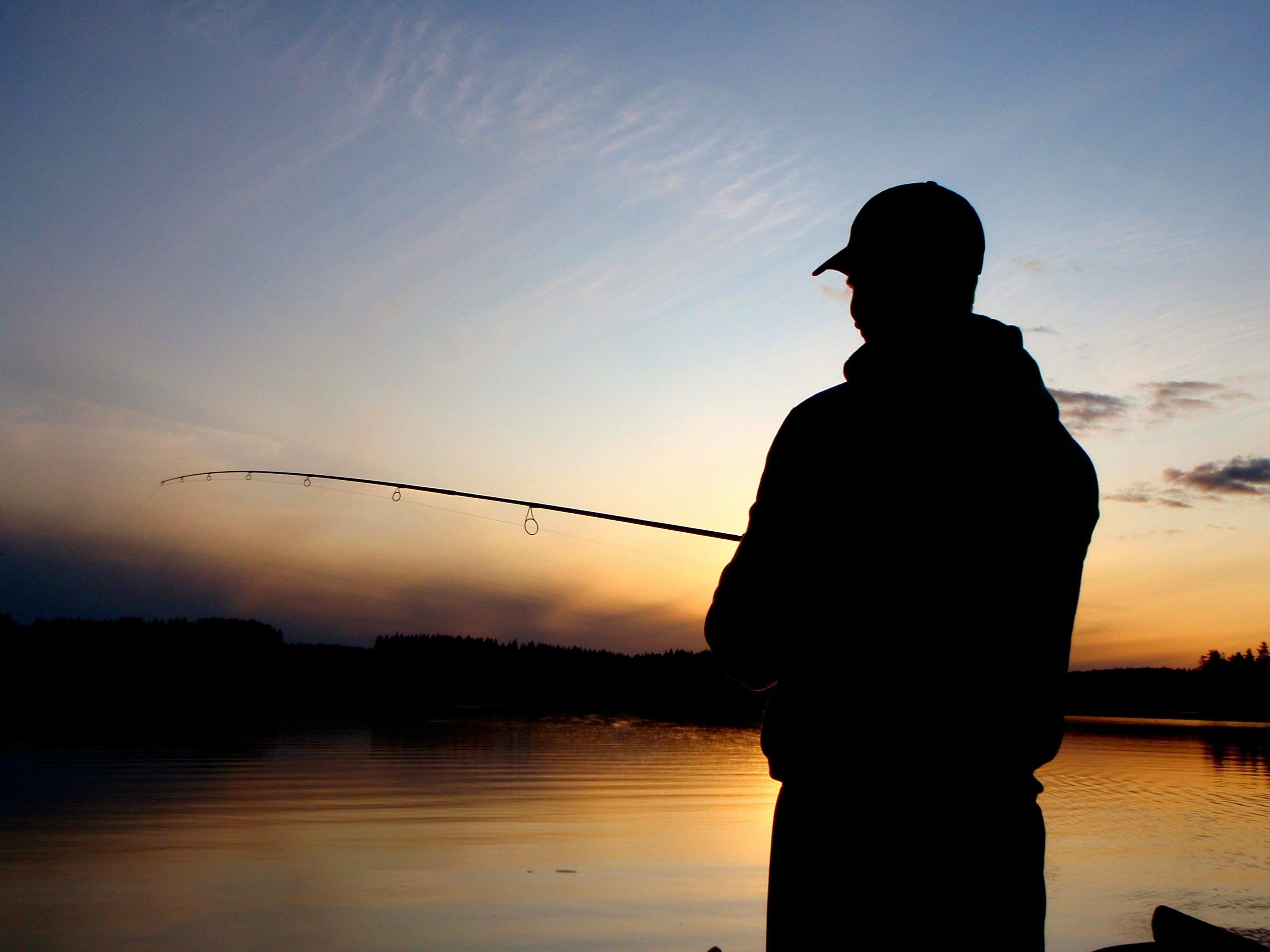 Ловить рыбу ночью. Рыбак с удочкой. Рыбак со спины. Спиннингист на закате. Рыбак на закате.
