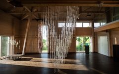Det største, monumentale verket "Stille, faren er over" fyller midten av det store rommet på Glasslåven, med lange glassformer hengende i piggtråd. Foto: Elin Osjord