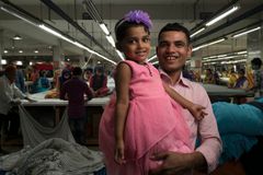 Jamal Hossain, 26, industriarbeider ved Northern Tosrifa Group klesfabrikk, med sin datter, Jui, 30 måneder, i Gazipur, utenfor Dhaka, Bangladesh