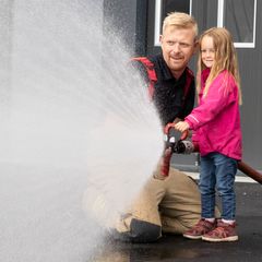 På Åpen brannstasjon lærer barna om brannvern og får prøve brannslanger.