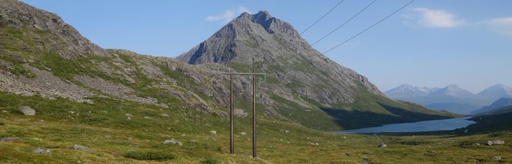 Fjellandskap Isfjorden. Ny H-mast med strømledninger. Fotomontasje: Multiconsult