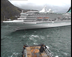 Her bukseres Artania inn mot kai i Honningsvåg av NSO Crusader, som er et av Kystverkets slepefartøy som patruljerer området fra Røst til nordområdene og grensen til Russland.