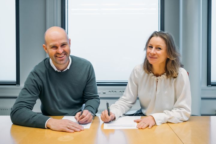 Styreleder Anders Kvåle i Spacemaker og konserndirektør Ida Aall Gram i AF Gruppen signerer avtalen om langsiktig samarbeid.