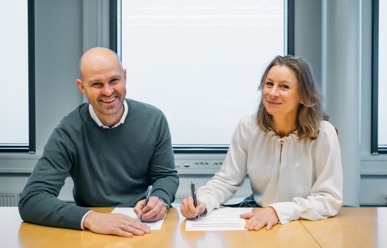 Styreleder Anders Kvåle i Spacemaker og konserndirektør Ida Aall Gram i AF Gruppen signerer avtalen om langsiktig samarbeid.