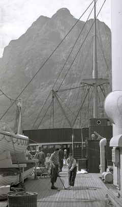 Shuffelboard ombord på D/S Stavangerfjord. Knut Lind reiste på tur med D/S Stavangerfjord langs kysten og opp til Svalbard. Fotografiet er fra denne turen.
Fotografiet er en del av en fotoserie med motiver av familien Lind. Flere av de mannlige familiemedlemmene i Lind-familien hadde ledende stillinger i Østlandske Petroleumskompani (senere Esso Norge). Det er private fotografier og portretter, foto av forskjellige anlegg knyttet til Esso, turer de har vært på i Norge og utlandet. Fotografiene er sannsynligvis tatt av Knut Lind (Arkivverket/Pa 0982 - Esso Norge A/S).