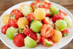 En ordentlig sommerdessert med jordbær, melon, honning og kokos.