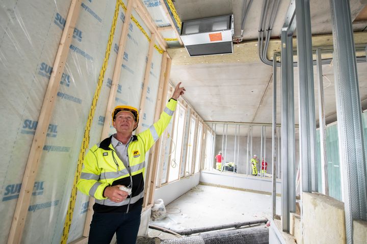 Ved hjelp av fjernvarme, varmepumpe, boligens eget varmtvann og én vifte i leiligheten har AF laget en helt ny og innovativ måte å varme opp OSUs leiligheter i Bjørvika på. Tor Olsen i AF viser løsningen. Foto: Katrine Lunke/Apeland