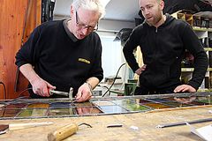 Johannes Paul Isaksen viser Endre Indergård hvordan blyglass monteres