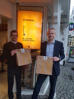 Daglig leder Adrian Lenart og driftsdirektør for Amka Holding as Kjetil Undem med McDelivery poser og plakat.