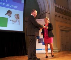 Øystein Børmer, direktør i Direktoratet for økonomistyring (DFØ), overrekker den nye metodeboken i samfunnsøkonomiske analyser til finansminister Siv Jensen.