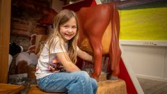 Barnemuseet er noe helt nytt i Norges museumslandskap og gir barna aktiv læring. Sofia Jakobsen, 8 år, melker Litago inne på gården.