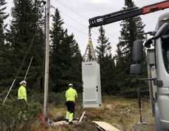 Batteriskapet settes på plass ved en strømstolpe i lavspenningsnettet på Sjusjøen.
