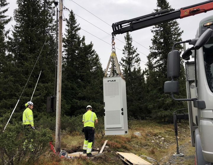 Batteriskapet settes på plass ved en strømstolpe i lavspenningsnettet på Sjusjøen.
