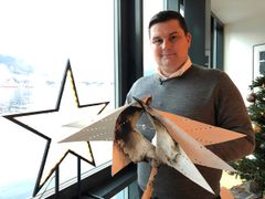 Brannekspert Øystein Øren i Frende viser frem en svidd adventsstjerne.
Denne begynte å brenne fordi papiret lå for tett mot lyspæra. Foto: Heidi Tofterå Slettemoen/Frende