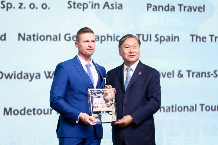 Dong CHEN (right), Party Secretary of Beijing Bureau of Culture and Tourism, gives an award to RANDALL DEER, founder and managing director of IGNITE TRAVEL of Australia.