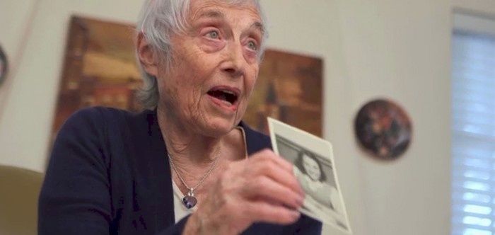 Nanette Konig viser frem et bilde av seg selv fra hun var 12 år gammel, samme år som hun ble tatt til fange av nazistene og fengslet i Bergen-Belsen. (Foto: National Geographic Channels)