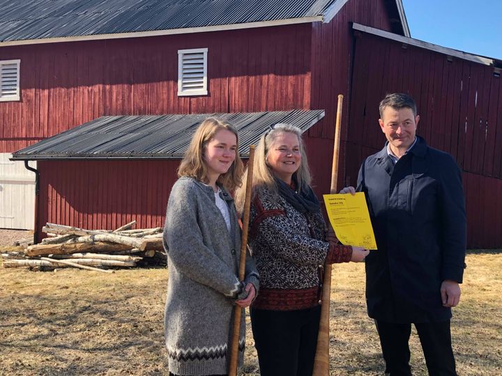 Anne Kristin Fosli fikk tidligere i april tildelt det synlige beviset på 350.000 kroner i støtte til låvebygningen på Søndre Vik gård i Nissedal. Prosjektet vil på sikt kunne gi noe næringsutvikling gjennom framtidig bruk til gårdsutsalg, kulturaktiviteter og julemarked. F.h. direktør i Kulturminnefondet Simen Bjørgen, Anne Kristin Fosli og datteren Malene. (Foto: Line Lyngstad/Kulturminnefondet)