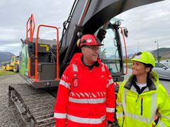Ingar Valbø, byggeleder i Statens vegvesen og Kamilla Busengdal, prosjektleder i Busengdal AS foran Sunnmøres største elektriske gravemaskin. Foto: Statens vegvesen