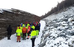 Sikringsvollen sikrar mot steinsprang og skred. Synfaringa går langs flaumløpet bak vollen. Foto: NVE