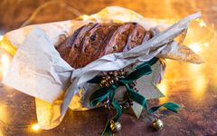 Til den som gleder seg til jul: Klassisk julebrød i beige silkepapir, grønt velurbånd og gullfarget julepynt. Foto: brodogkorn.no