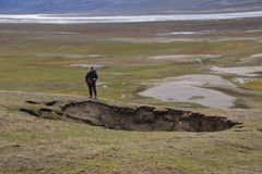 Figur 2. Synkehull ved Gjelhallet i Sassendalen på Svalbard som følge av at permafrosten under bakkeoverflaten har tint og jorden over har kollapset. Foto: Norsk Polarinstitutt/Cornelia Jaspers.