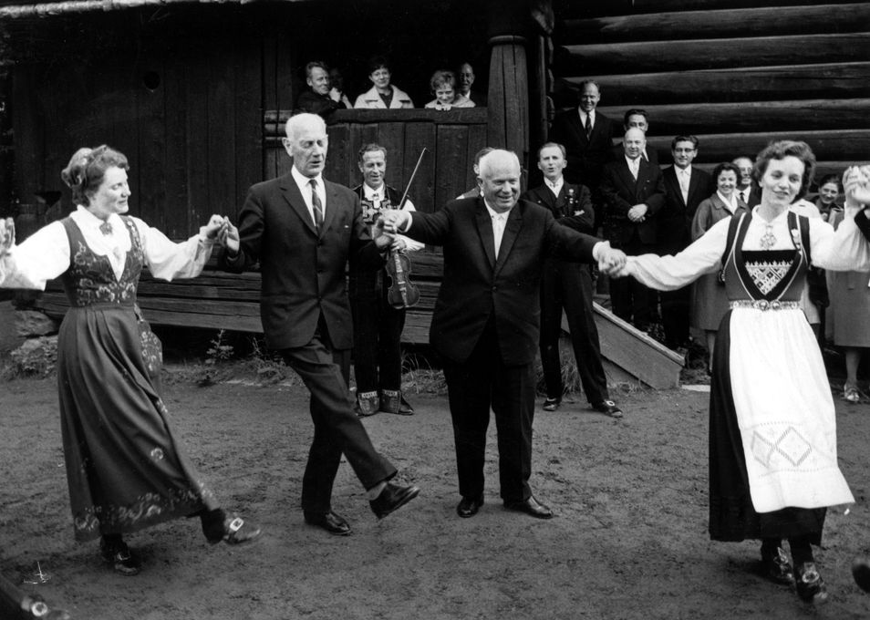 Sovjets leder Nikita Khrustsjov (til høyre) lærer å danse norsk folkedans under et statsbesøk i 1964 på Norsk folkemuseum på Bygdøy i Oslo. Her danser han sammen med Einar Gerhardsen. Foto: Erik Thorberg / NTB