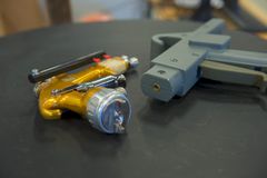 SRP Teach Handle (th) og en tradisjonell lakkeringspistol (tv).