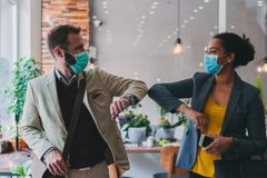 NYE RUTINER: Munnbind og nye måter å hilse på er blitt en del av hverdagen. Illustrasjonsfoto: Istock