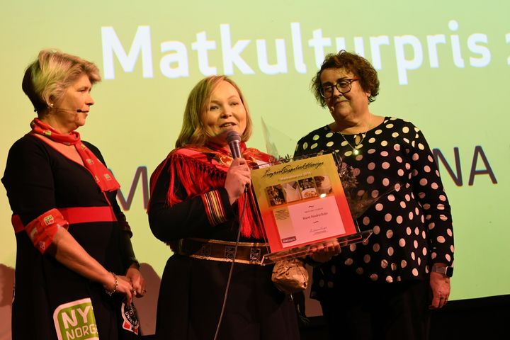 En rørt prisvinner Maret Ravdna Buljo i midten. Til venstre: Direktør i stiftelsen Matmerk, Nina Sundqvist. T. h: Landbruks- og matminister Olaug Bollestad. Foto: Matmerk