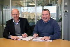 Konserndirektør Geir Kulås (t.v.) i Skagerak Nett og leder for ABBs mellomspenningsvirksomhet i Skien Ken Isaksen signerer rammeavtalen for nettstasjoner, bryteranlegg og transformatorer.