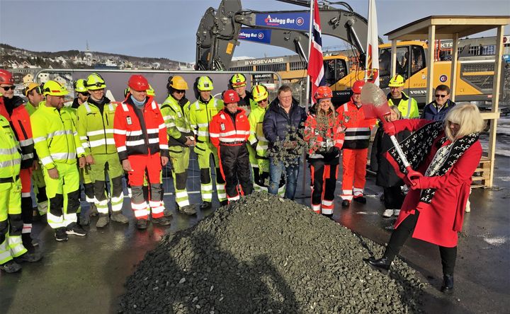 Ordfører i Harstad, Kari-Anne Opsal, tar første spadetak i Harstadpakkens trinn to foran en feststemt gjeng fra Statens vegvesen, Harstad kommune, Troms og Finnmark fylkeskommune og entreprenørselskapet, Anlegg Øst AS. Foto: Statens vegvesen.