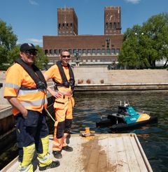 Skal bruke dronen. Edvin Wibetoe (overingeniør i Oslo Havn) og Steven Dahl  (driftstekniker Oslo Havn) på bryggekanten ved Honnørbrygga, med dronen i bakgrunnen. Foto: Oslo Havn