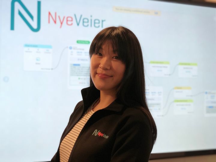 - Nye Veier er først ute i Norge til å bruke Messenger og chatbot-teknologi som informasjonskanal for trafikknyheter., sier Linn Herredsvela, senior kommunikasjonsrådgiver i Nye Veier. Her står hun foran et flytskjema for chatboten.