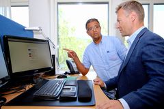 Signeringsløsningen fra Digipost letter arbeidsdagen til arkivmedarbeider Abdelilah Lemriri. Her viser han løsningen til kommunikasjonssjef Torkel Bergstøl (t.h.) i Nittedal kommune.