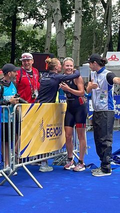 Løvseth får en klem fra Lotte Miller. Sportssjef Arild Tveiten bak. Foto: Olalla Cernuda fra World Triathlon/Norges Triatlonforbund. Kan brukes fritt av norsk presse.