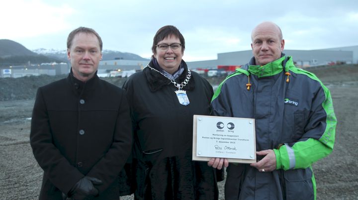F.v.: Odd Roger Tiller fra Posten, ordfører Rita Ottervik og Leif Ivar Skjærvik fra Bring gleder seg til den enorme terminalen snart skal reise seg på tomten bak dem. FOTO: Jørn Michalsen / Posten